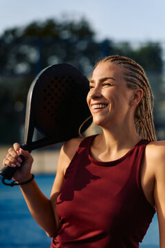 Happy female player on padle tennis court.