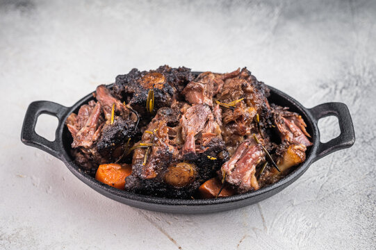 Homemade beef oxtail ragout in cast iron skillet, gelatin rich slow cooked meat with garlic and rosemary