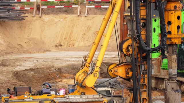 Heavy drilling rig installing deep foundation piles at a construction site, showing geotechnical engineering, groundwork and structural construction