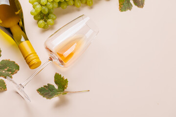 Fototapeta premium Overhead wine glass and grapes on a blush background