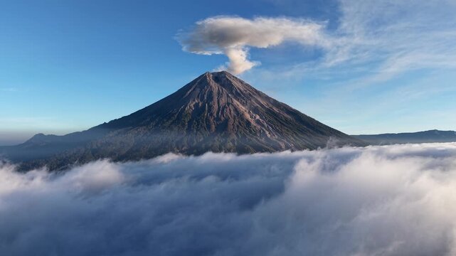 Dramatic Mount Semeru eruption plume towering above a sea of clouds at sunrise.