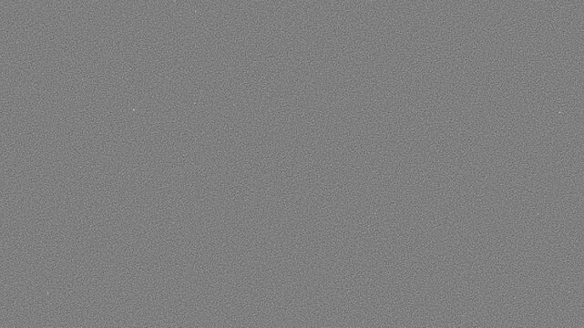 Uniform analog film grain overlay with fine noise texture covering neutral grey surface