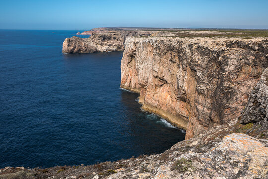 Dramatic ocean cliffs near Cape Saint Vincent under a clear blue sky - Sagres, Portugal