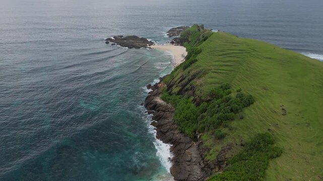Aerial Drone View Emerald Headland With Rocky Cliffs, Secluded White Sand Cove, Turquoise Surf And Lush Grass Slopes Calm Overcast Light, Survey Mood, Ideal For Conservation, Bukit Merese, Lombok
