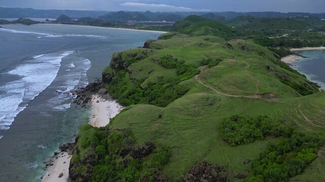 Wide Drone Shot Rugged Coastline And Ocean Under Moody Sky Deep Blue Water, Crashing Waves On Basalt Cliffs, Distant Islets, Group of Tourists, Bukit Merese, Lombok, Tanjung Ann