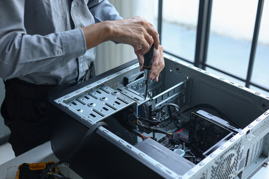 IT engineer installing components inside a computer system unit for upgrading computer PC.
