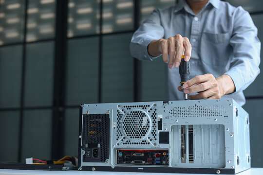 IT engineer installing components inside a computer system unit for upgrading computer PC.