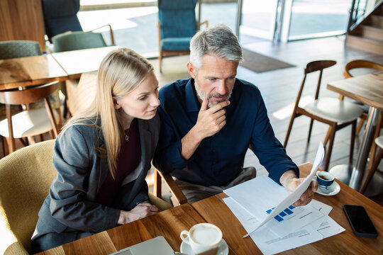 Colleagues reviewing a financial report together in a cafe