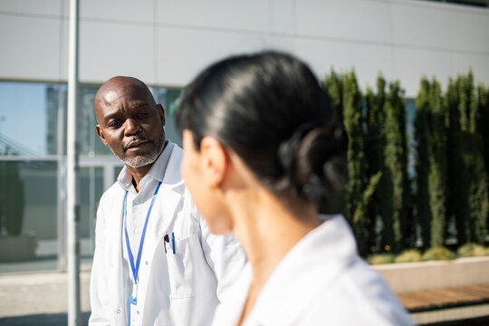 Doctor listening to colleague outside the hospital