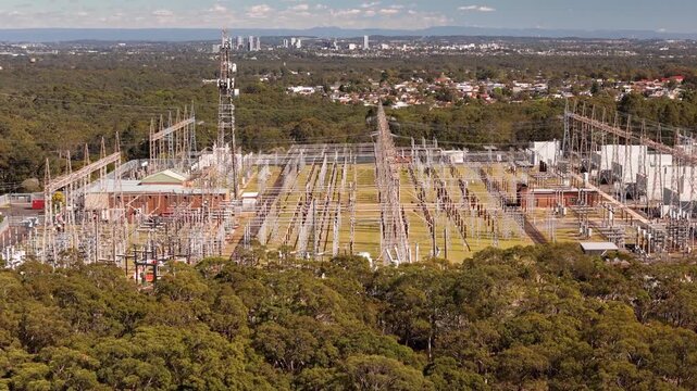 Aerial drone rising up view of a large electrical distribution substation for the generation and supply of energy to households and industry located at Picnic Point in Sydney, NSW Australia  