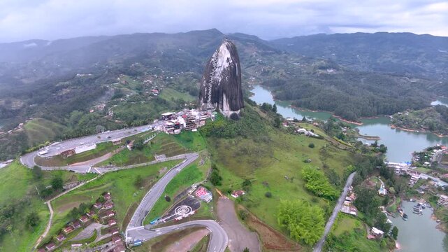 Guatap&eacute; and Iconic Piedra del Pe&ntilde;ol Surrounded by Reservoir Islands and Mountains in Colombia. Establishing Shot. Aerial View.