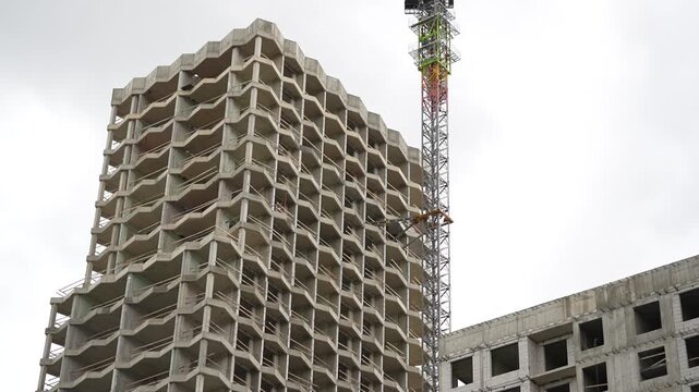 Unfinished high rise concrete structure with tower crane, representing large scale construction, structural engineering, real estate development and urban growth