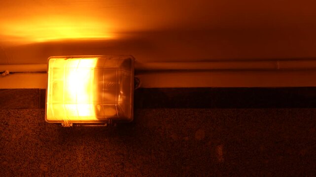Warm illuminated wall fixture inside an underground pedestrian underpass, representing public space lighting, pedestrian safety and essential urban infrastructure