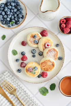 Cottage cheese pancakes with fresh blueberries, raspberries and mint on a plate