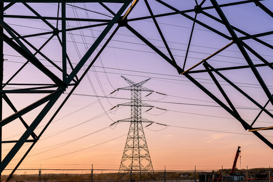 Energy grid infrastructure with high voltage pylons.