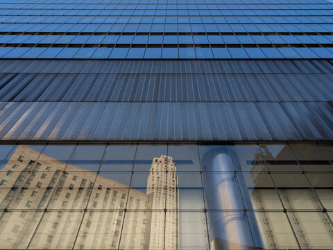 New York City, New York &ndash; October 3, 2026: Glass curtain wall and metal louvers on the facade of an office building in Lower Manhattan, with reflections of other buildings in the glass.