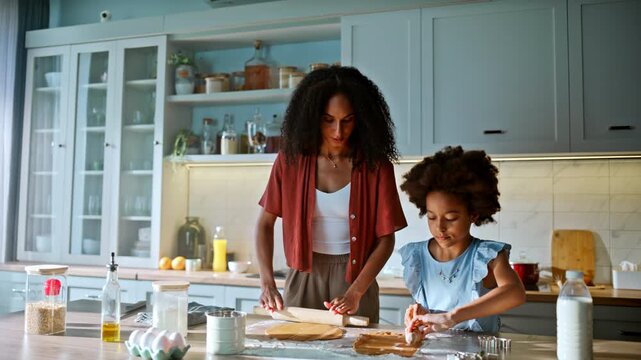 Cheerful kid helping mom bake cookie dough home kitchen. Rolling pastry parent.