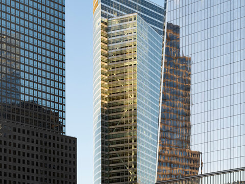 New York City, New York &ndash; October 3, 2026: Glass office skyscrapers against a blue sky at the World Trade Center, Lower Manhattan, with a reflection of a tower in the glass at right.