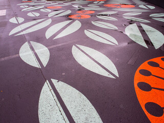 Modern floral street art painted on wet asphalt pavement © mcgimpseymike