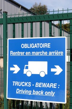 Mandatory reverse parking sign on a fence called rentrer en marche arri&egrave;re in French language