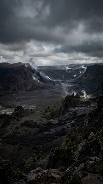 Dark Stormy Mountain Landscape with Cloudy Sky and Rugged Terrain.