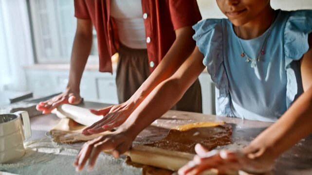 Mother daughter rolling gingerbread dough. Closeup hands pin kitchen.
