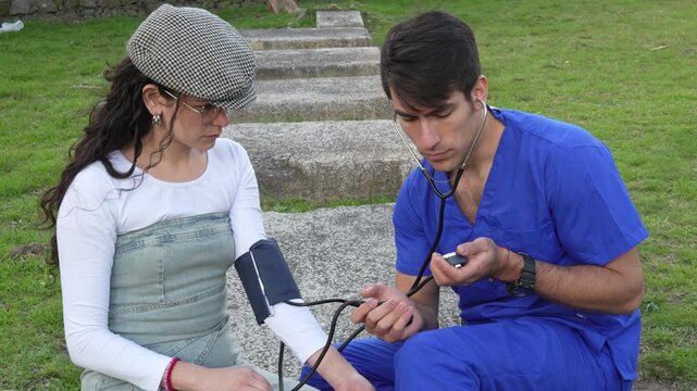 Paramedic checking vital signs and blood pressure of a patient outdoors