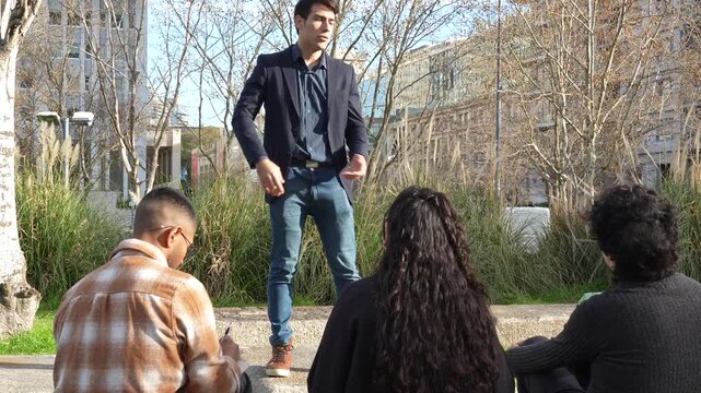 Speaker giving outdoor presentation to attentive audience taking notes in park