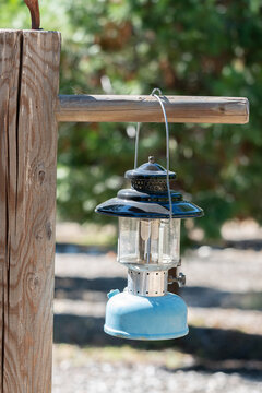 Vintage Blue Camping Lantern Hanging From Wooden Post