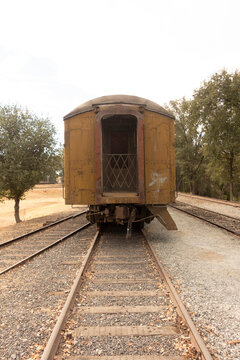 Rear View of Weathered Vintage Rail Carriage on Railroad Tracks