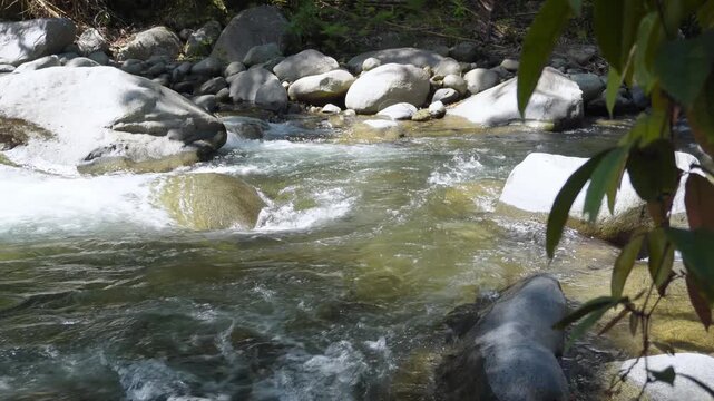 Crystal Clear River Flowing Between Boulders