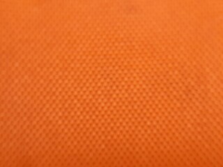 Obraz premium blurred orange fabric texture background with subtle dot mesh pattern