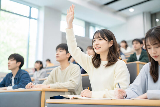 講義中に教室で手を挙げる女子学生