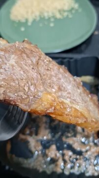 Person serving well-done steak with white rice on a plate, homemade lunch preparation and traditional everyday meal