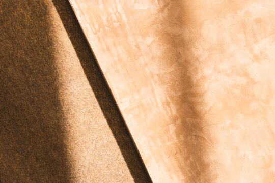light and shadow on brown stone wall of building background