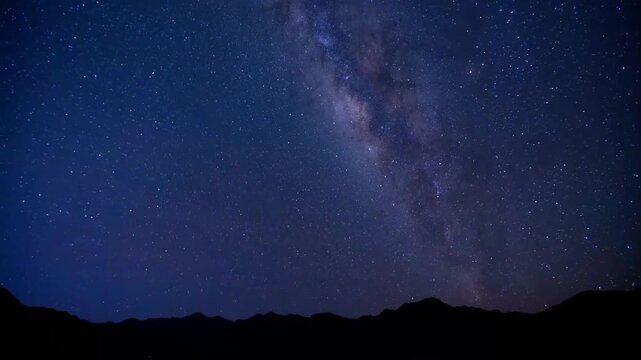 Milky Way galaxy arching over dark mountain silhouettes at night with meteor streaks, transitioning to golden sunrise above sea of clouds