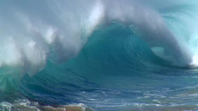 Powerful ocean wave curling into a turquoise barrel and crashing with explosive white foam spray
