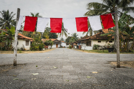 Red and White Bunting Flags Over Quiet Tropical Village Street