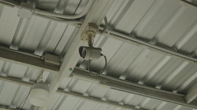 Ceiling-mounted security camera under corrugated metal roof