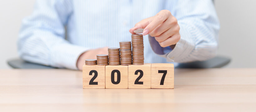 Happy New Year 2027 with Coins stack. Money, Budget, tax, investment, financial, savings and New Year Resolution concepts
