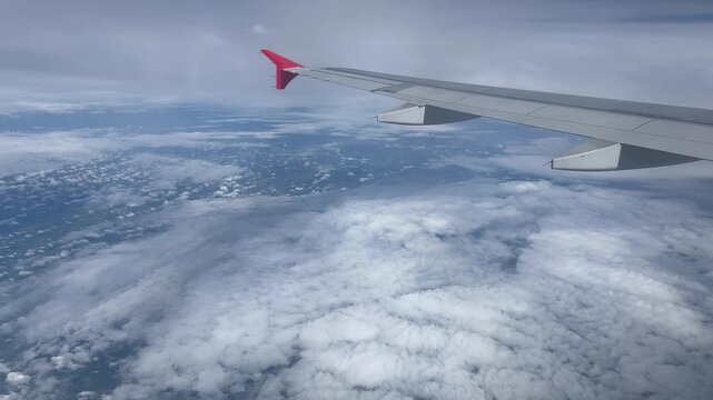 Beautiful window view while traveling by an airplane above the clouds.