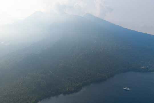 Late afternoon sunlight shines on the volcanic island of Makian, just south of Ternate near Halmahera, Indonesia. The coral reefs of this region support extraordinary marine biodiversity.