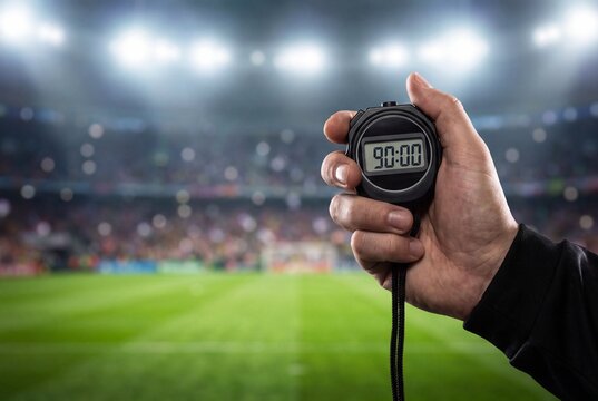 Referee Holding Digital Stopwatch Showing Ninety Minutes at Football Stadium