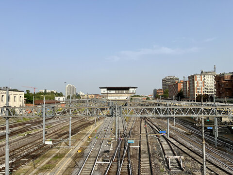 Train tracks junction with overhead lines and control center building in Bologna, Italy
