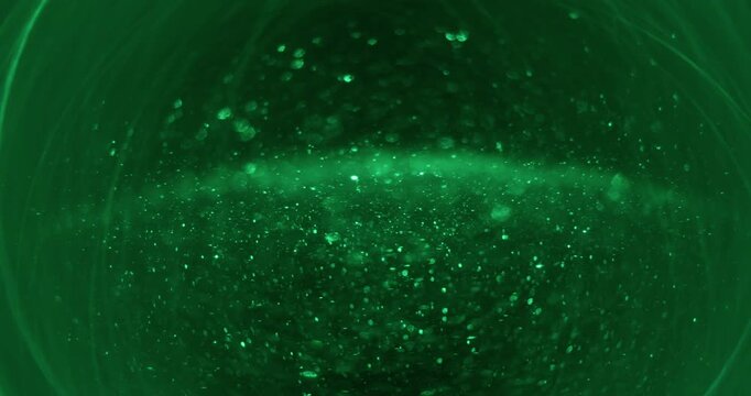 Blur stardust sphere. Round circles. Green neon color illuminated optical lens flare motion on abstract visual bokeh light background.