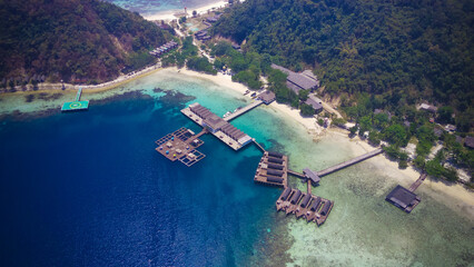 Aerial view of tropical overwater resort bungalows with helipad and wooden jetty © rhpermana