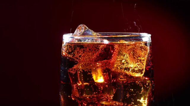 Refreshing cola pouring into glass with ice cubes creating fizzy bubbles and splash effect.