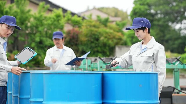 A group of workers inspecting drums