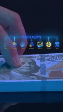 Hand holding cash banknotes below glowing cash flow text hub vertical shot with income and profit icons. Corporate capital liquidity management, revenue stream analysis, and value concept idea.