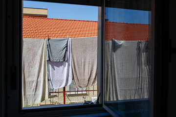 Fototapeta premium Towels Drying on Clothesline Outside Window, Mediterranean Home with Terracotta Roof
